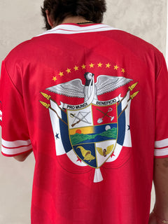 Red sports jersey with a prominent emblem on the chest.