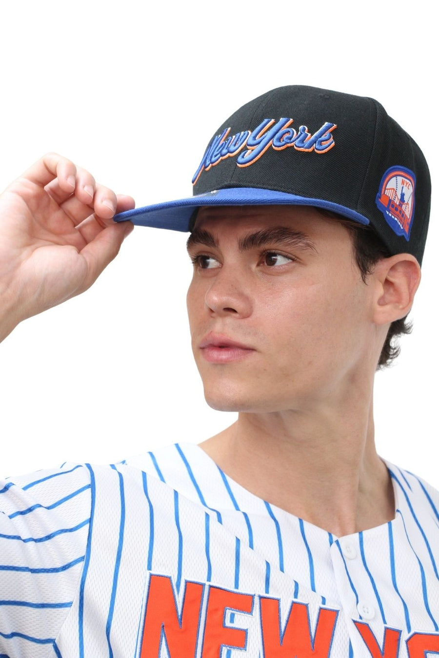 Person wearing a black and blue cap with 'New York' text, looking to the side.