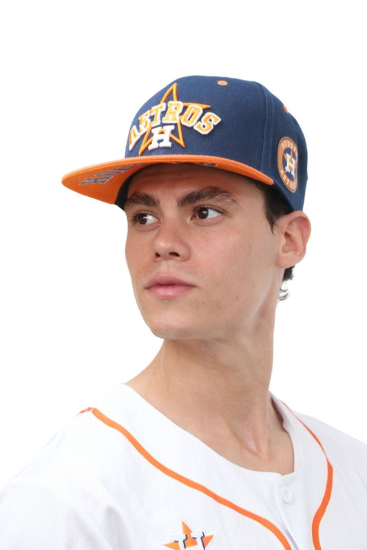 A person wearing a blue and orange snapback cap with 5D and 3D embroidery on it.