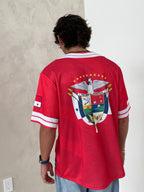 Person wearing a red sports jersey with a logo on a plain background