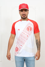 Person wearing a white and red baseball-style shirt with graphics, standing against a plain background.