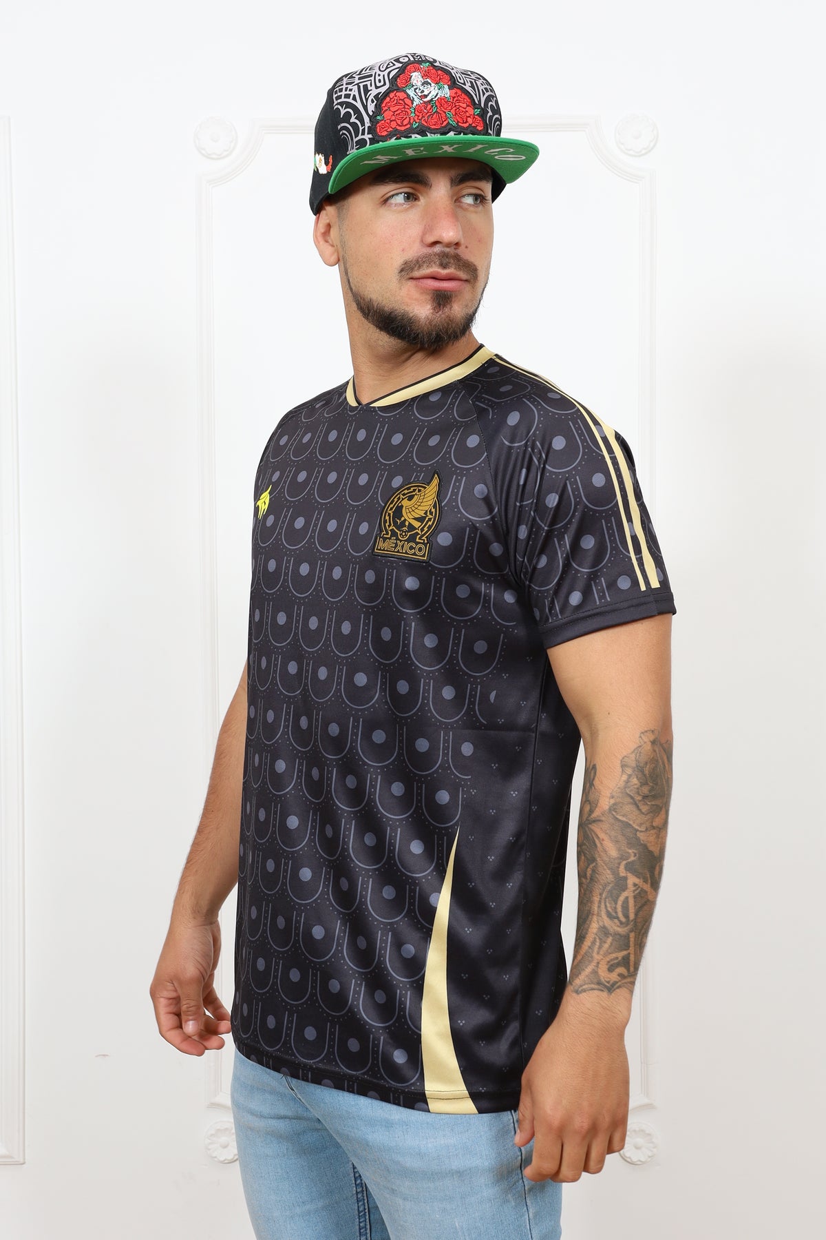 Person wearing a black patterned jersey with gold accents on a white background