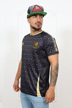 Person wearing a black patterned jersey with gold accents on a white background