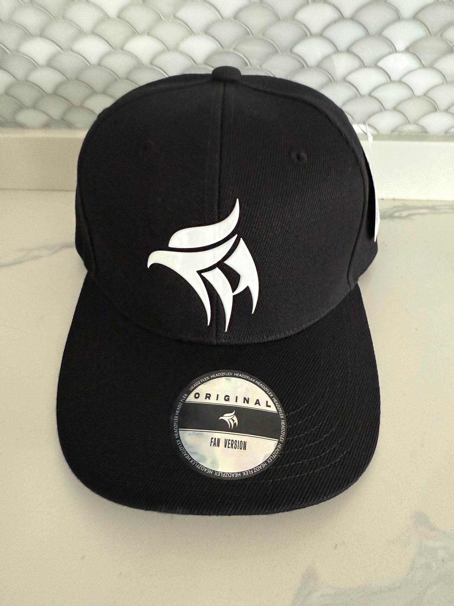 Two black caps with logos on a textured white background