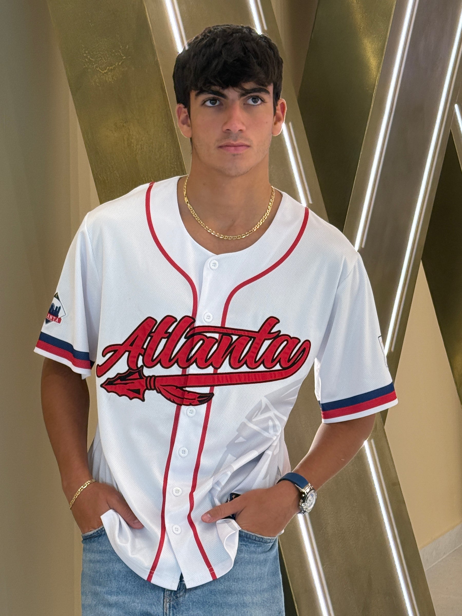 Atlanta baseball jersey 13 - Person wearing a white sports jersey with red lettering in an indoor setting