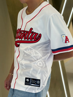 Atlanta baseball jersey 13 - Person wearing a white baseball jersey with red and blue details, featuring the word 'Atlanta'.