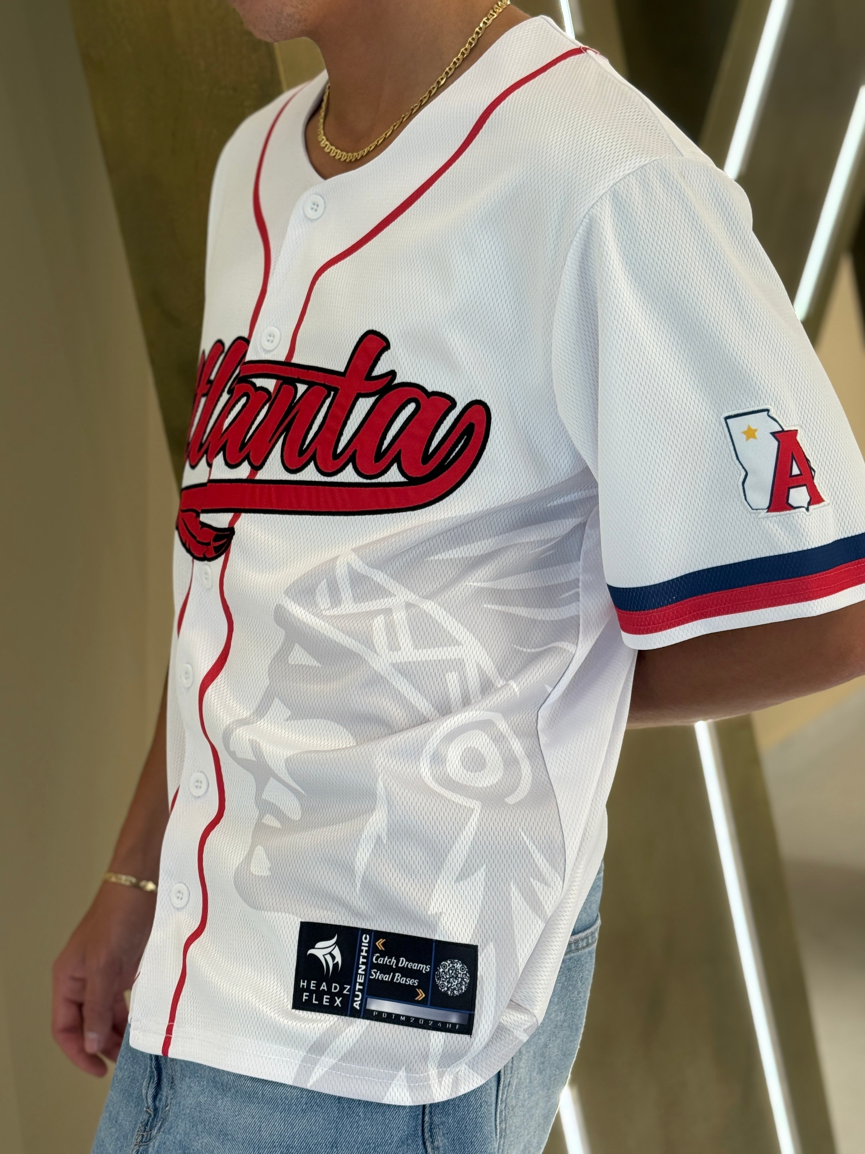 Atlanta baseball jersey 13 - Person wearing a white baseball jersey with red and blue details, featuring the word 'Atlanta'.