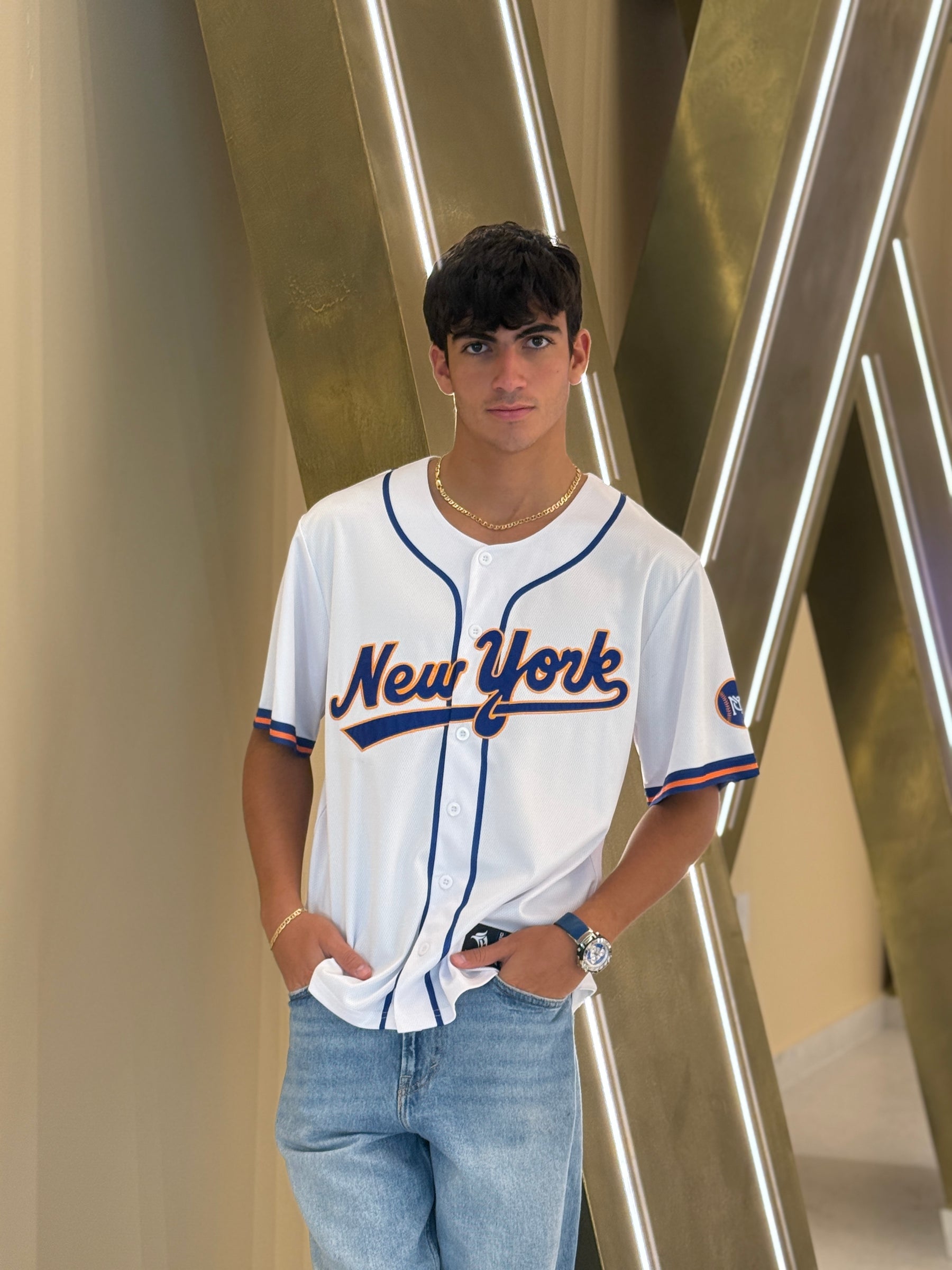 Person wearing a New York baseball jersey standing against a modern interior background