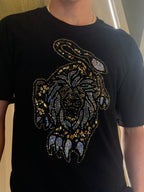 Black t-shirt with a tiger face design made of rhinestones worn by a person.