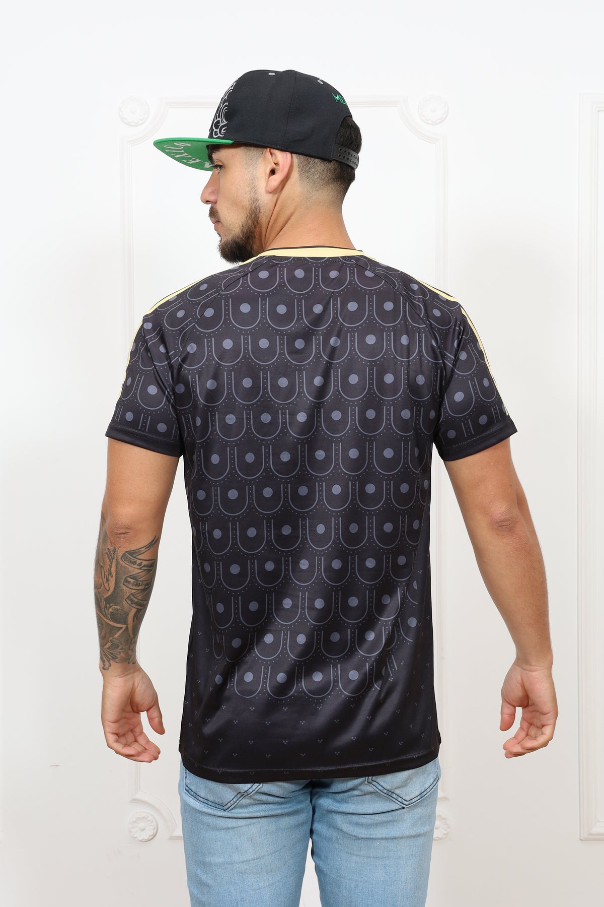 Person wearing a patterned shirt and jeans on a white background