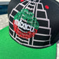 A black structured cap with embroidered Maya pyramids and Quetzalcoatl snake, featuring the Mexican map and coat of arms on the sides, red vent holes, and a flatbill with sublimated symbols.