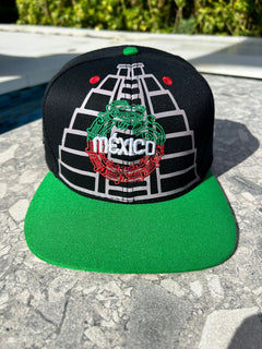 A black structured cap with embroidered Maya pyramids and Quetzalcoatl snake, featuring the Mexican map and coat of arms on the sides, red vent holes, and a flatbill with sublimated symbols.