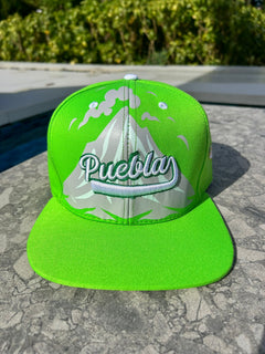Green cap with 'Puebla' text on a stone surface