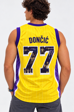 Woman wearing the West Coast 77 yellow and purple basketball jersey with a purple cap in Los Angeles