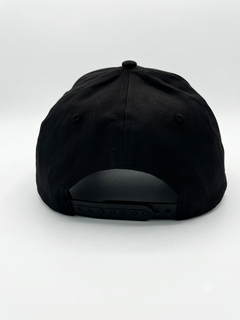 Adjustable black snapback hat with rear plastic closure, back view
