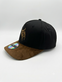 Golden Emblem black and gold snapback hat with brown textured brim, angled front view