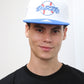 A person wearing a blue and white Los Angeles Dodgers fan cap with 5D embroidery and a structured crown.