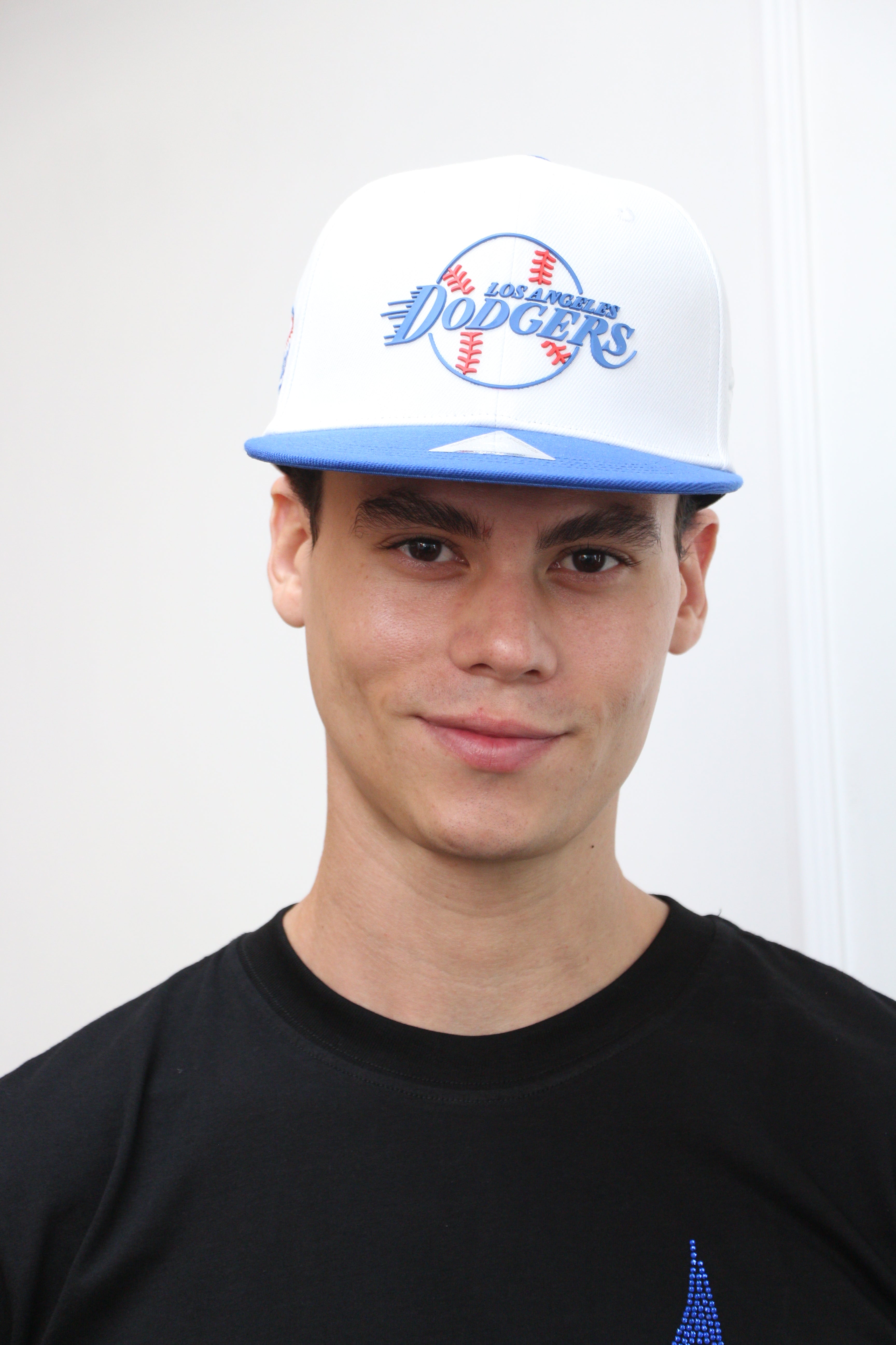 A person wearing a blue and white Los Angeles Dodgers fan cap with 5D embroidery and a structured crown.