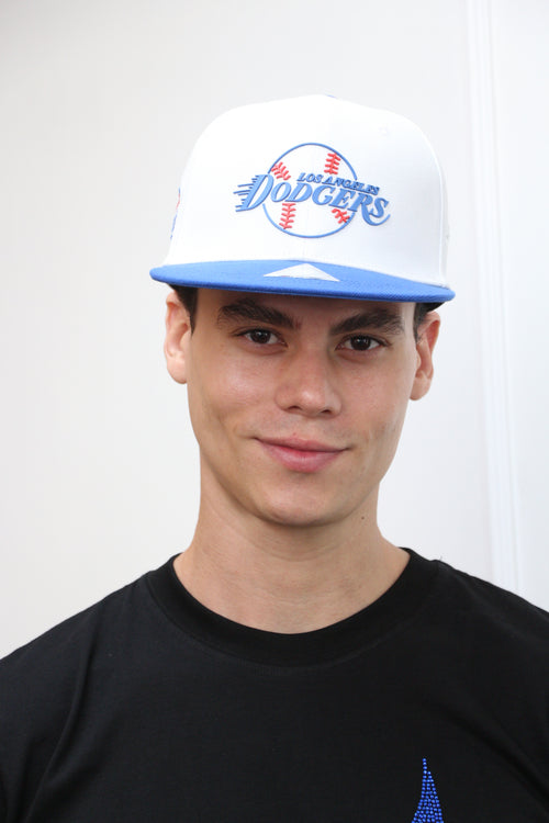 A person wearing a blue and white Los Angeles Dodgers fan cap with 5D embroidery and a structured crown.