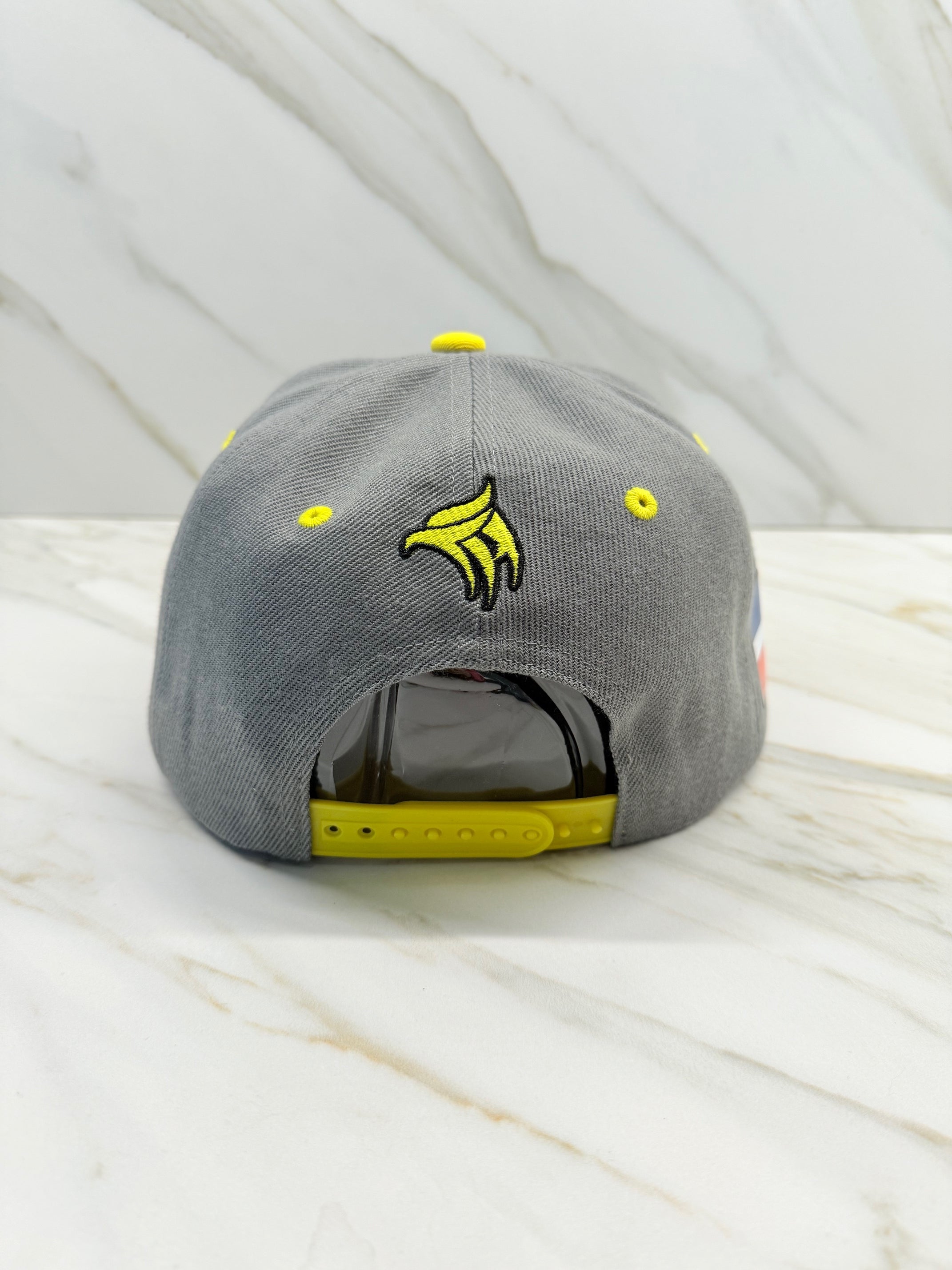 Gray Águilas Cibaeñas Snapback Cap back view with yellow strap and embroidery

