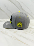 Side view showing Águilas Cibaeñas logo patch on gray snapback cap

