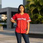 Person wearing a red Panama baseball jersey outdoors with greenery in the background