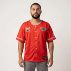 Man wearing a red baseball jersey with logos on a white background