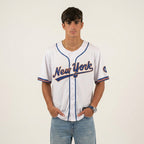 Person wearing a New York baseball jersey on a plain background