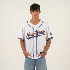 Person wearing a New York baseball jersey on a plain background
