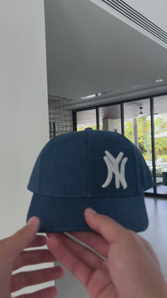 Video: New York denim snapback cap shown in hand, front view of raised NY embroidery